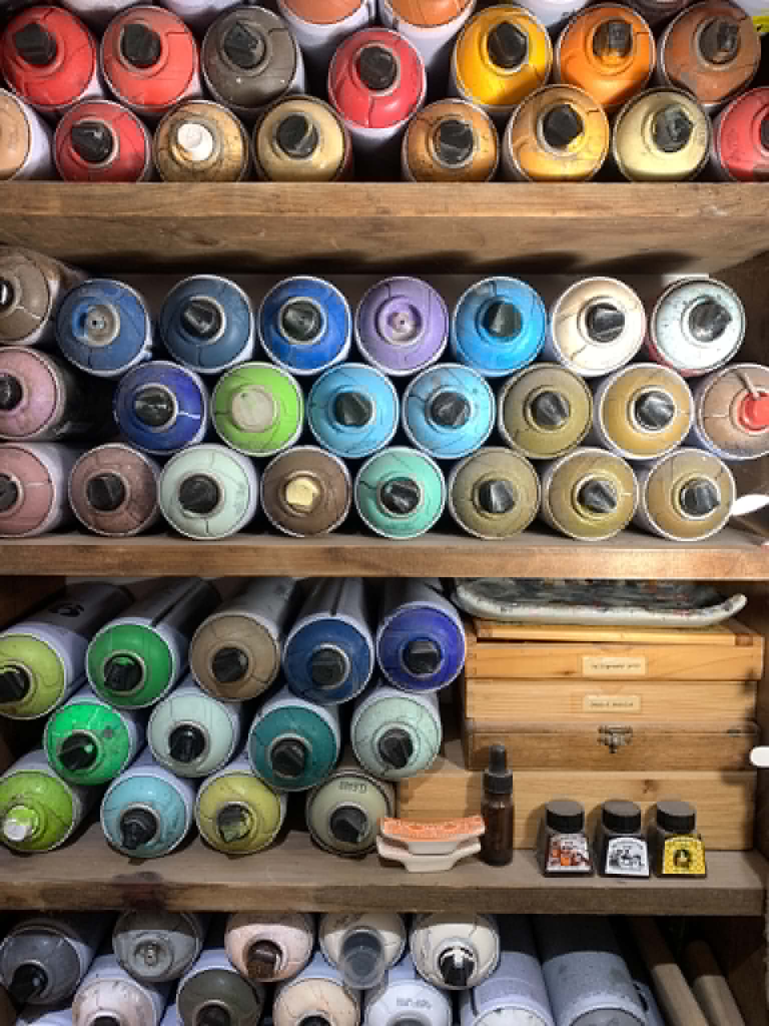 Shelves of rolled papers, pigments and studio materials in Chris White’s studio.